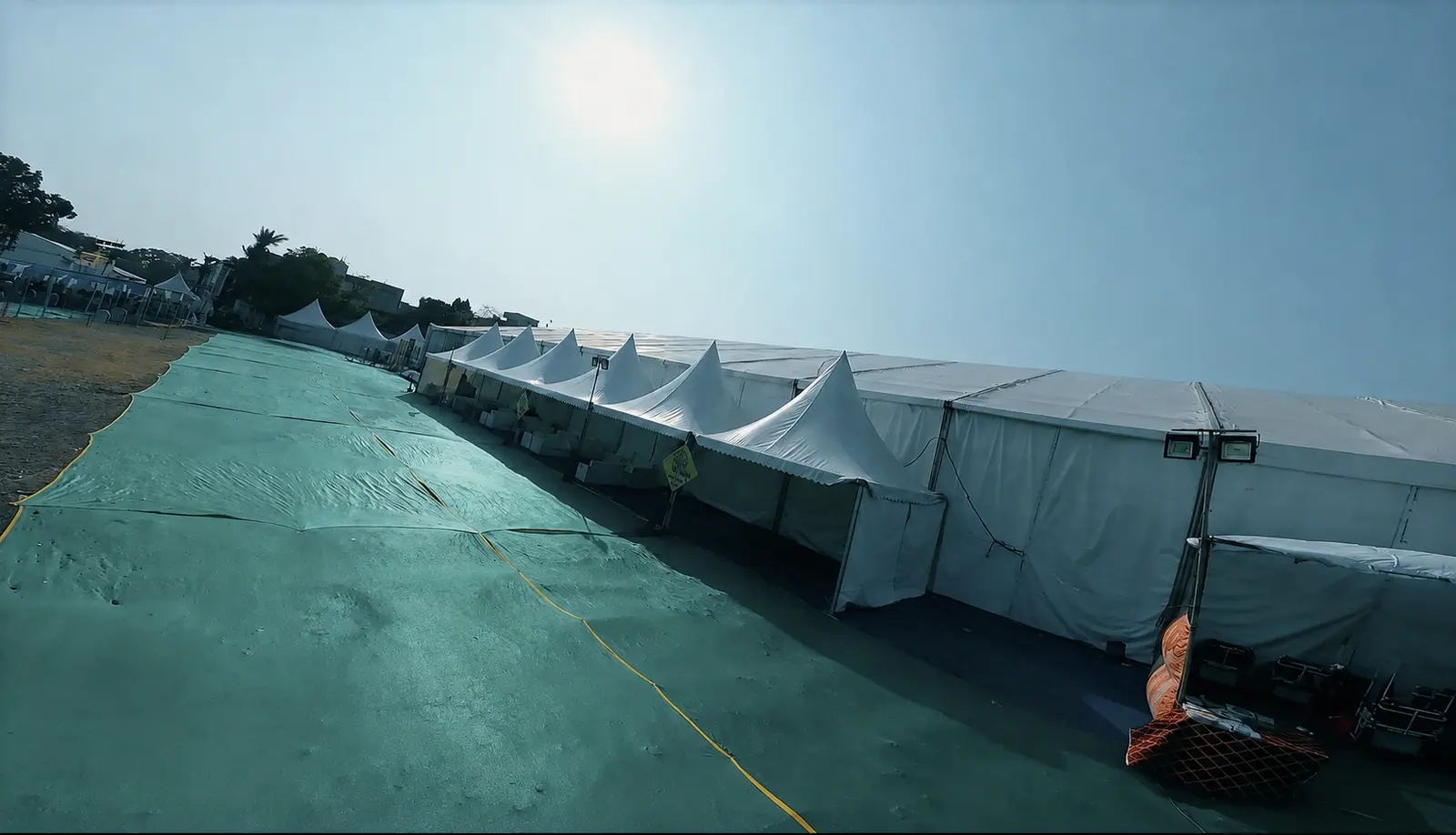 Multiple temporary canopy structures arranged across a prepared operating site