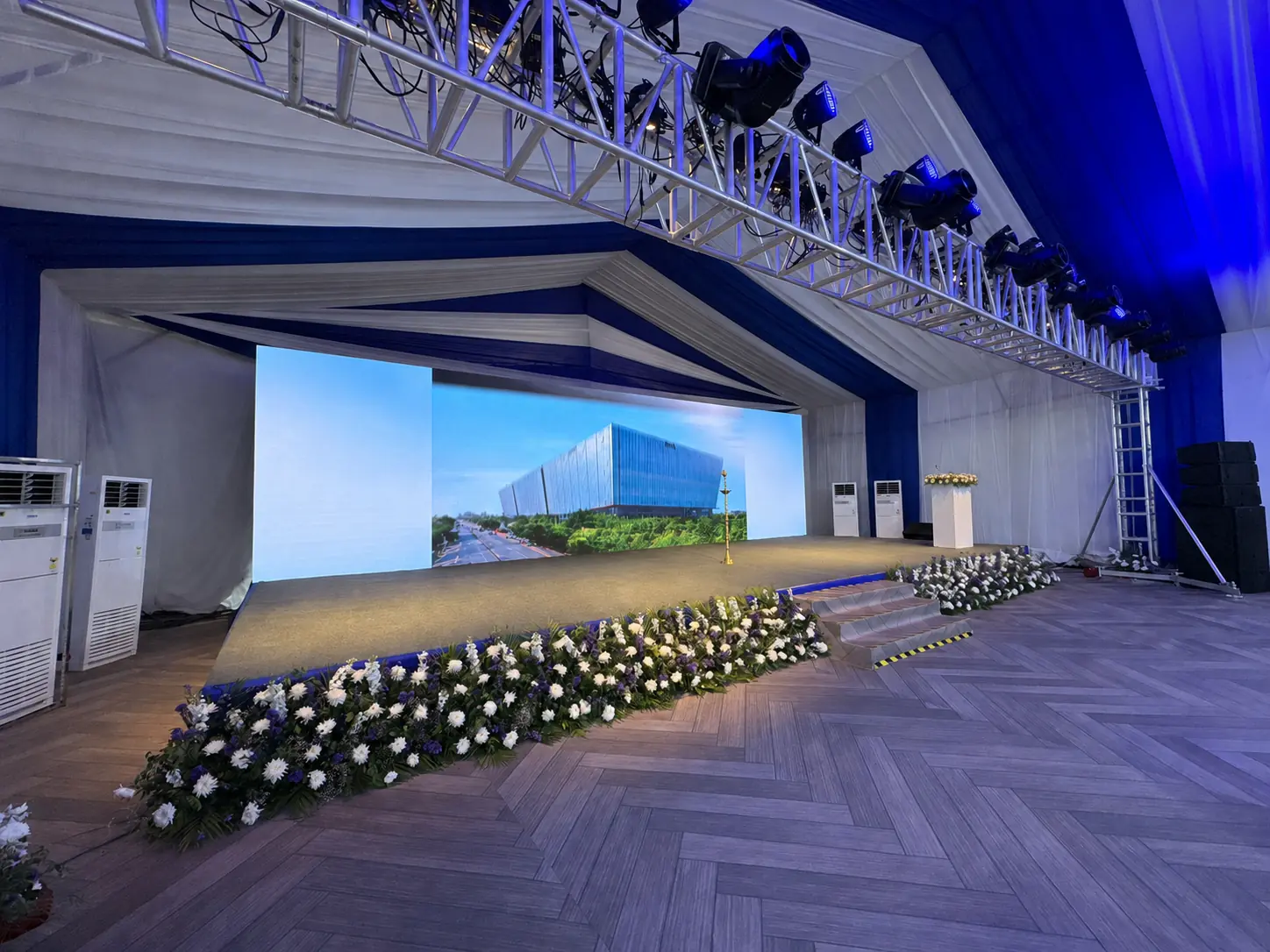 Clear-span temporary hall with an integrated stage and truss system